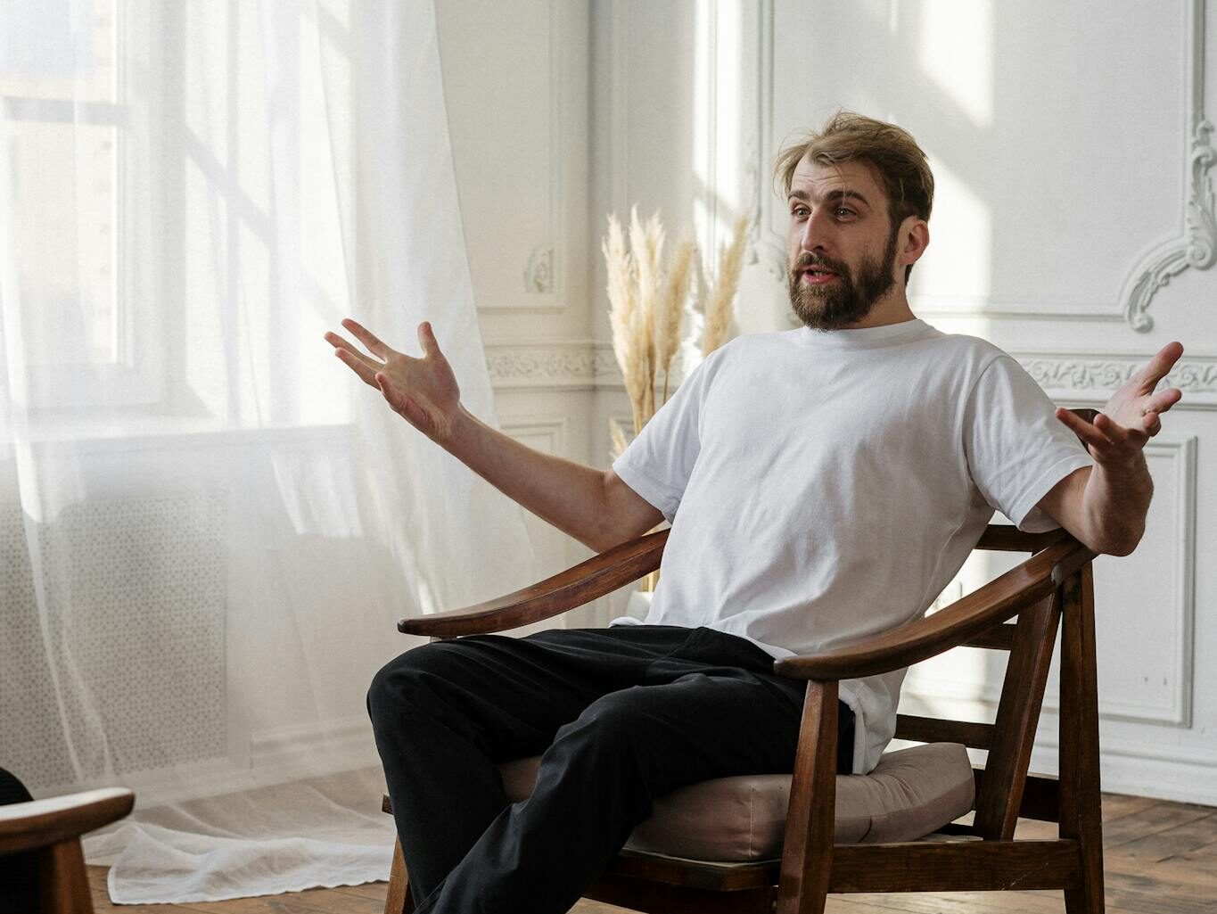 A therapist discusses with a patient in a bright, sunlit room for a mental health session.